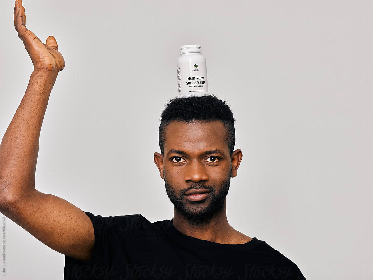 Playful man with hair growth product on top of his head