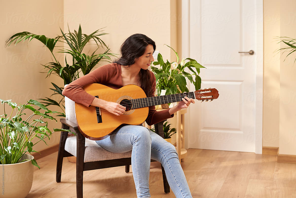 Woman playing ukulele at home