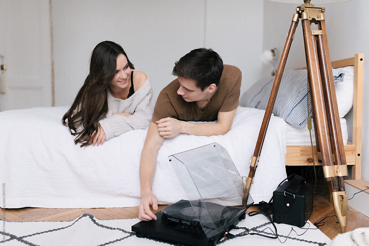 Couple with vinyl player on bed