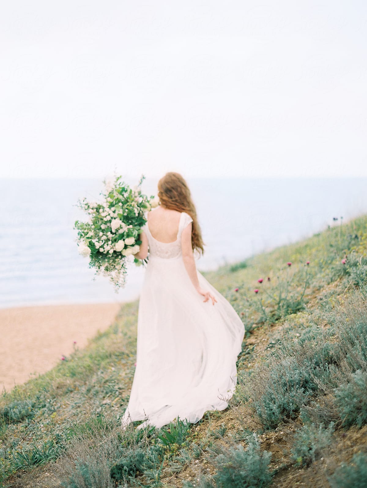 Girl in dress with flowers on beach