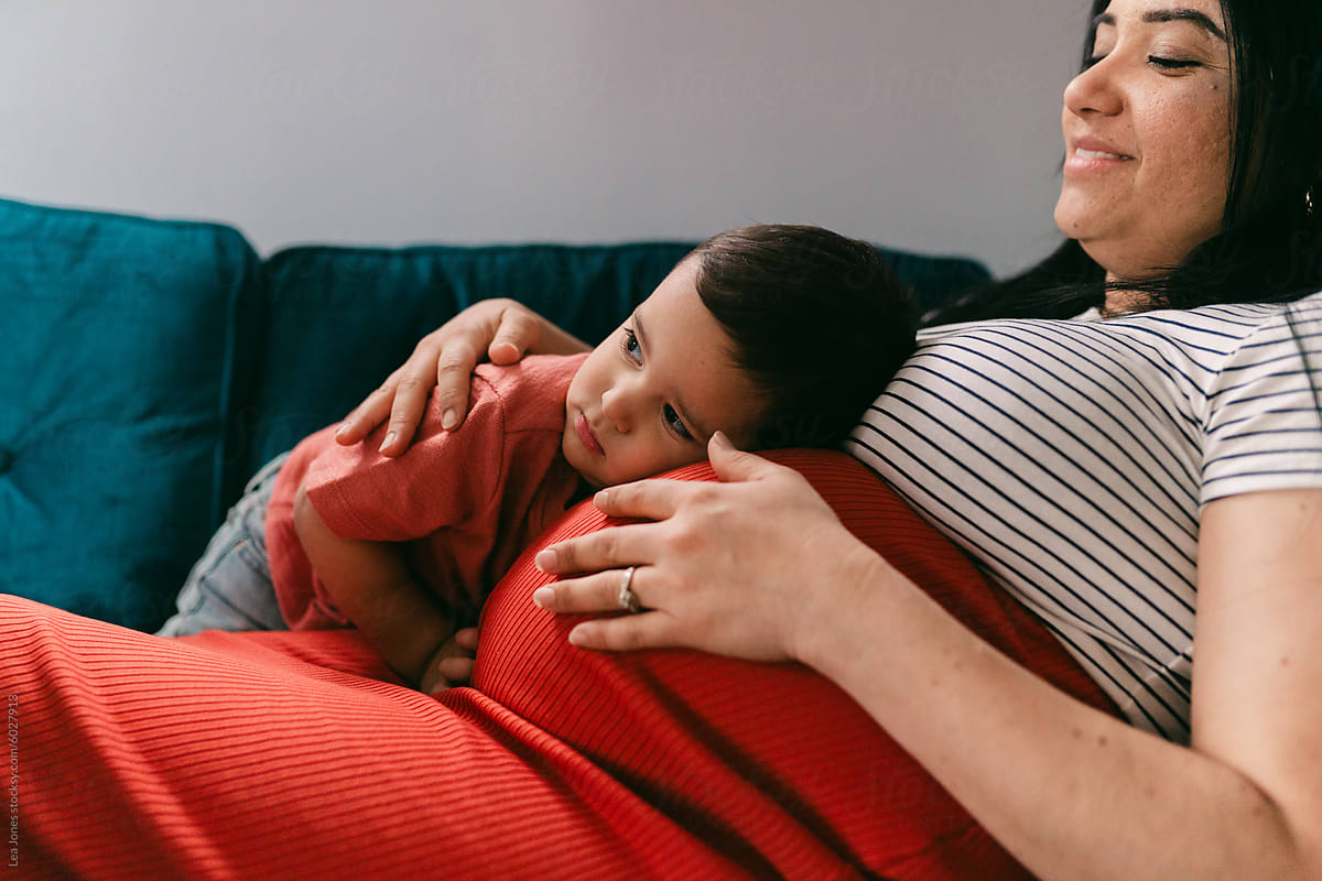 pregnant  mother cuddling toddler on the couch
