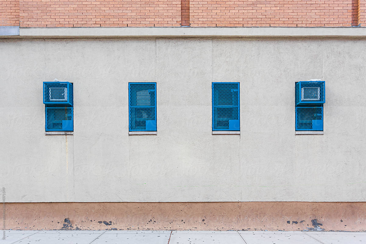 blue windows on a wall in the empty street