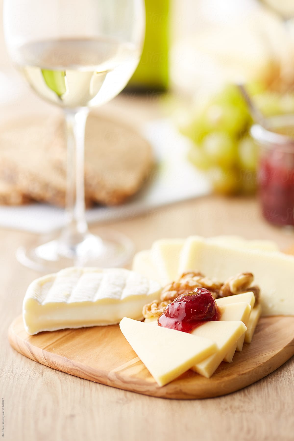 Cheese board with walnuts, jam and wine