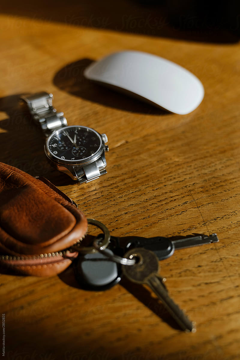 Wristwatch and Keys  on an Desk
