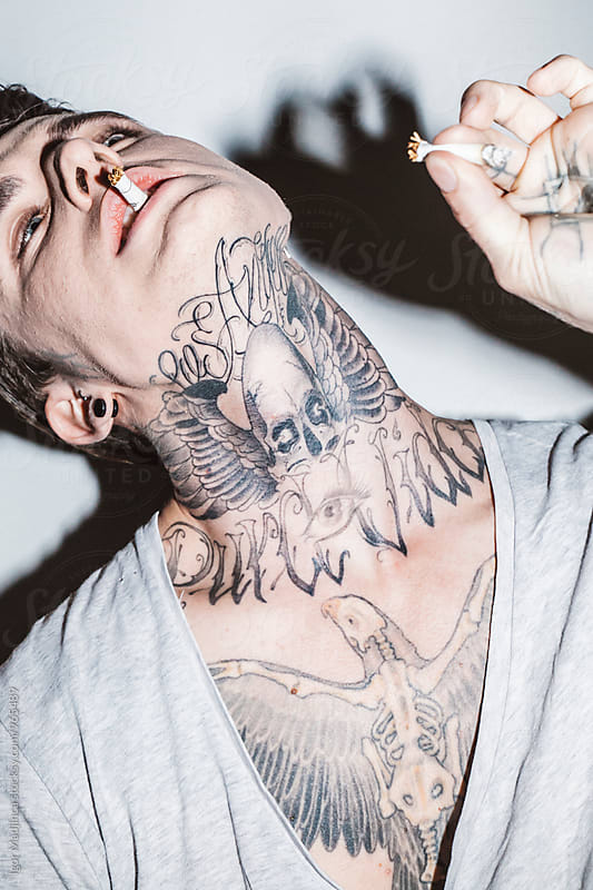 Shadow,skull,Fashionable tattooed guy with a modern haircut and a cigarette, attitude