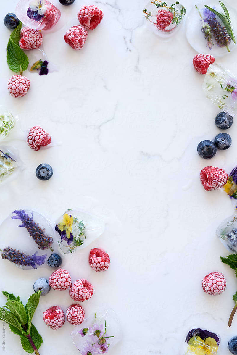 Food background with frozen berries and flowers in ice
