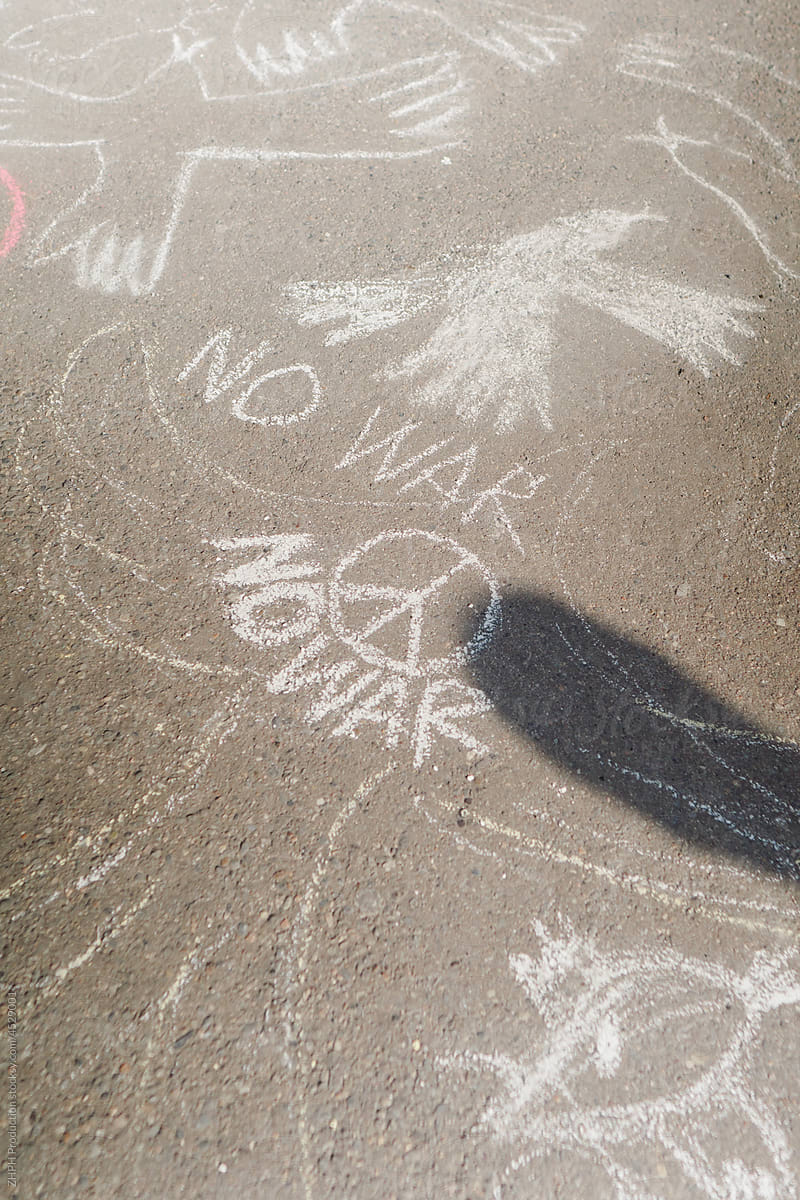 Woman drawing anti-war art with chalk on the street