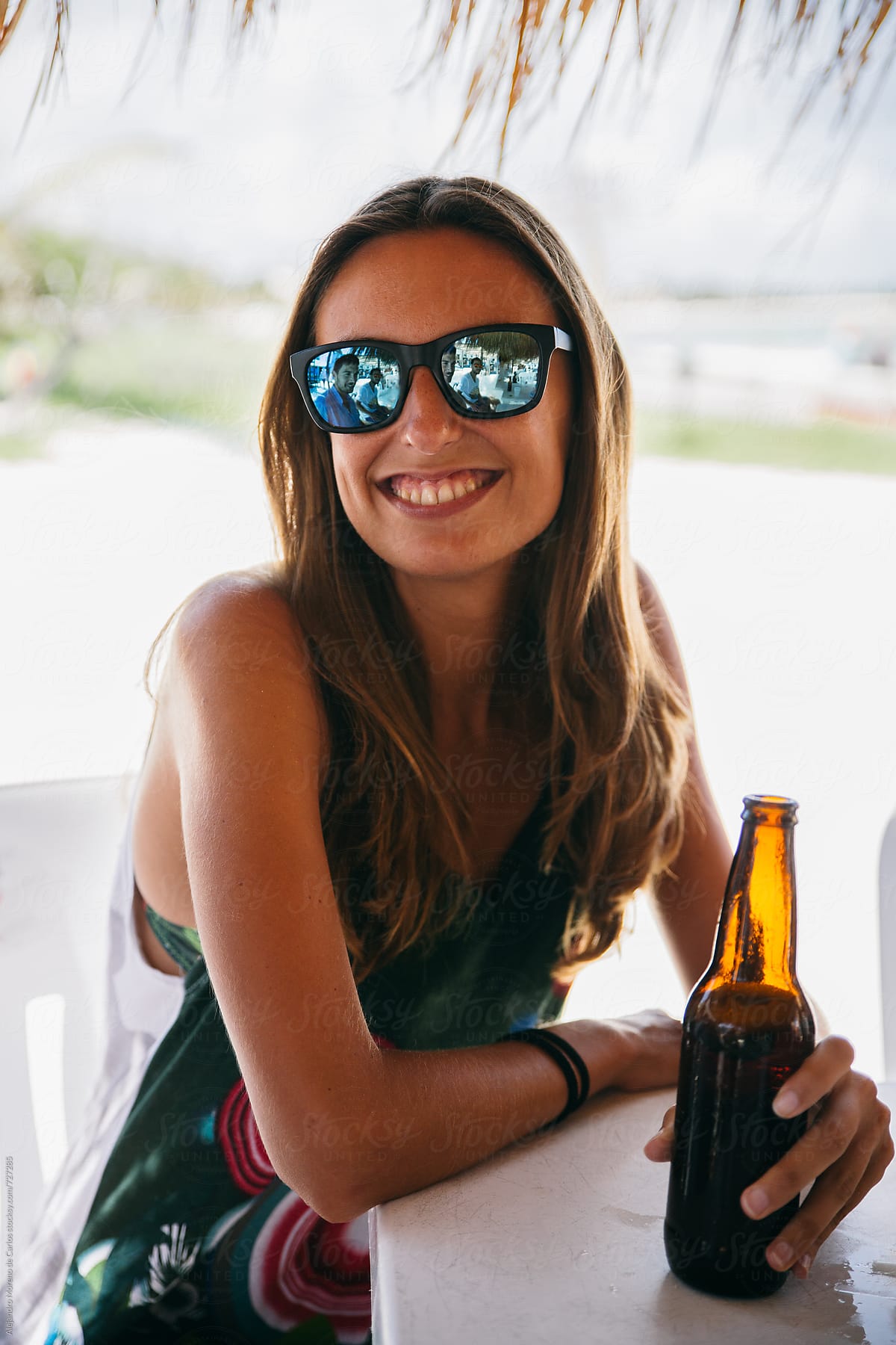 Young Smiling Woman With A Beer Bottle In A Beach Bar By Stocksy Contributor Alejandro Moreno 