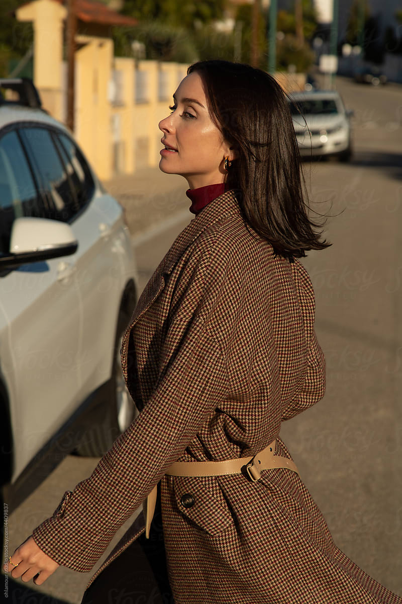 a stylish woman walking down the street to her car