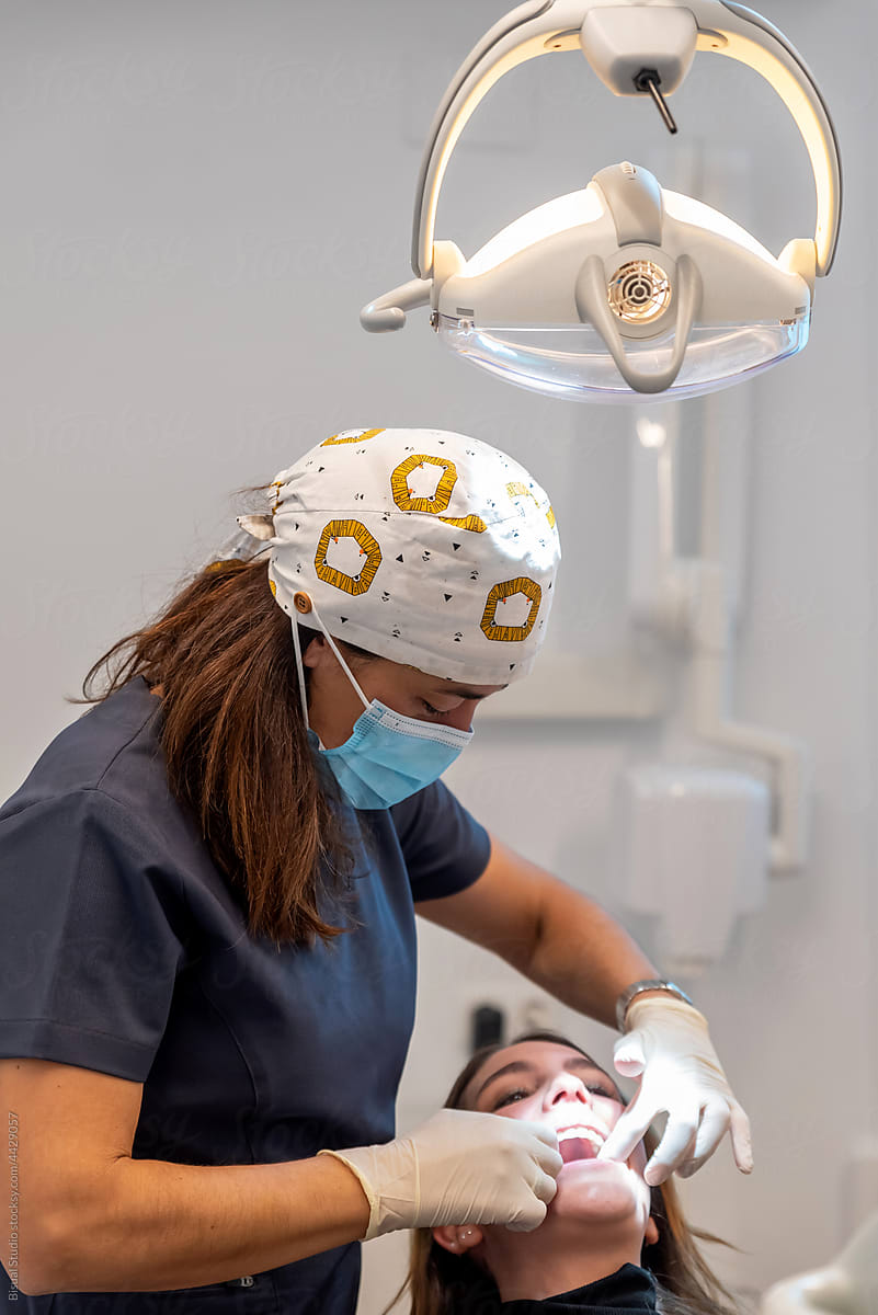 Female dentist examining teeth of female client