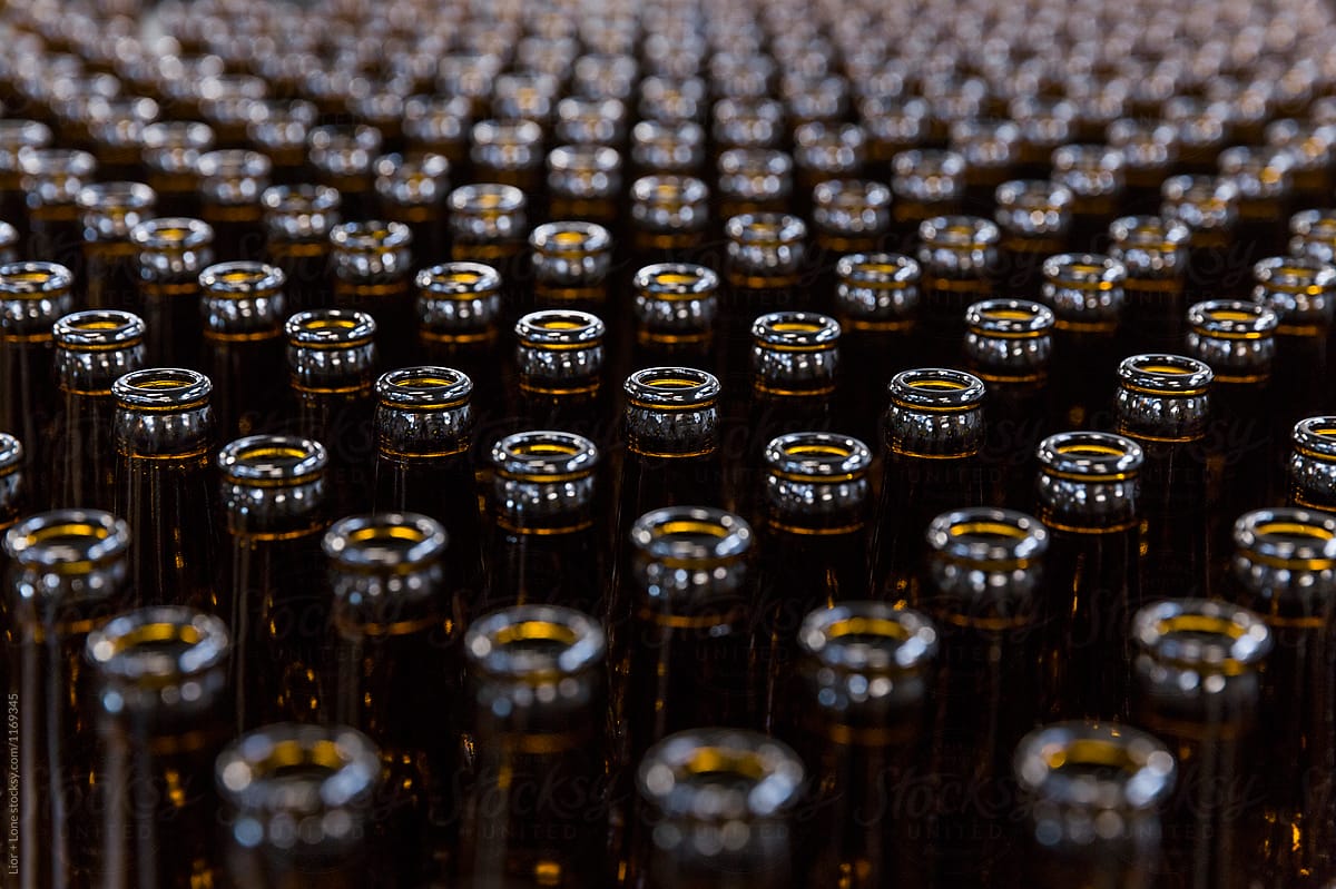 Symmetrical rows of empty beer bottles shot from above