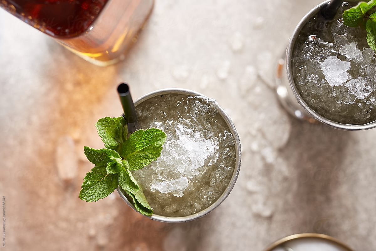 Two Mint Julep drinks with mint and straws.