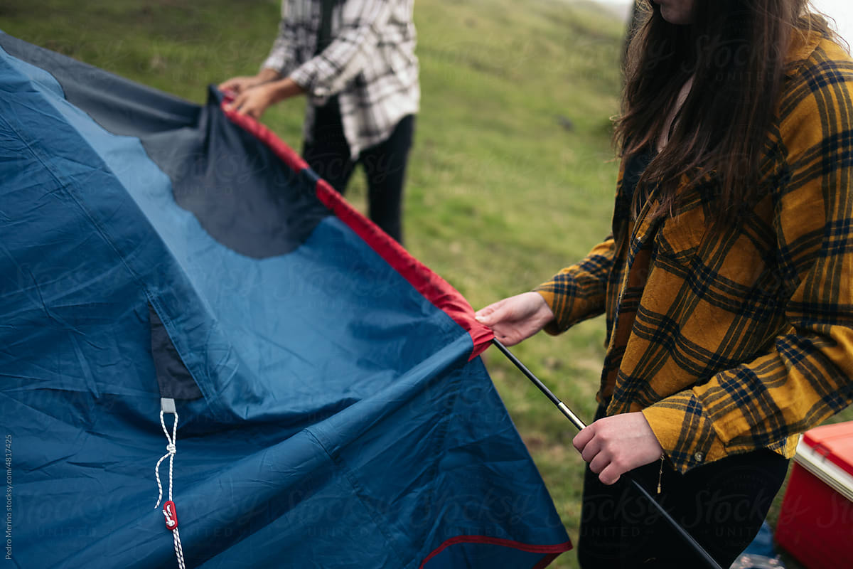 Couple setting up a tent in the forest for camping