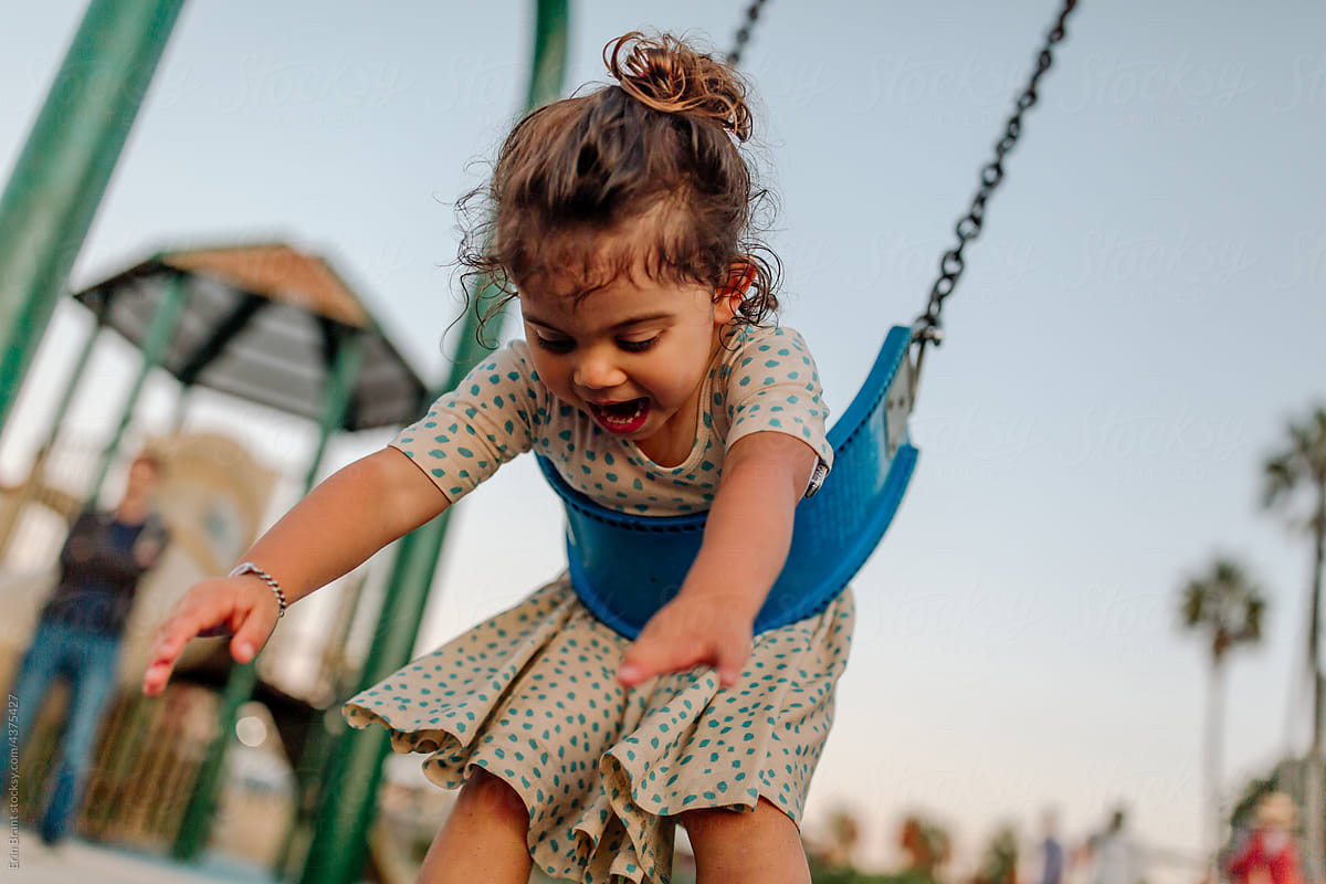 Happy girl with limb difference on swing