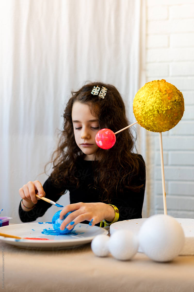 Kid girl doing a handmade Solar System Craft at home