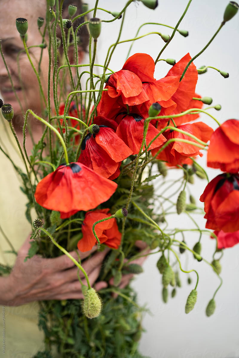 Woman with a bouquet of wild poppies