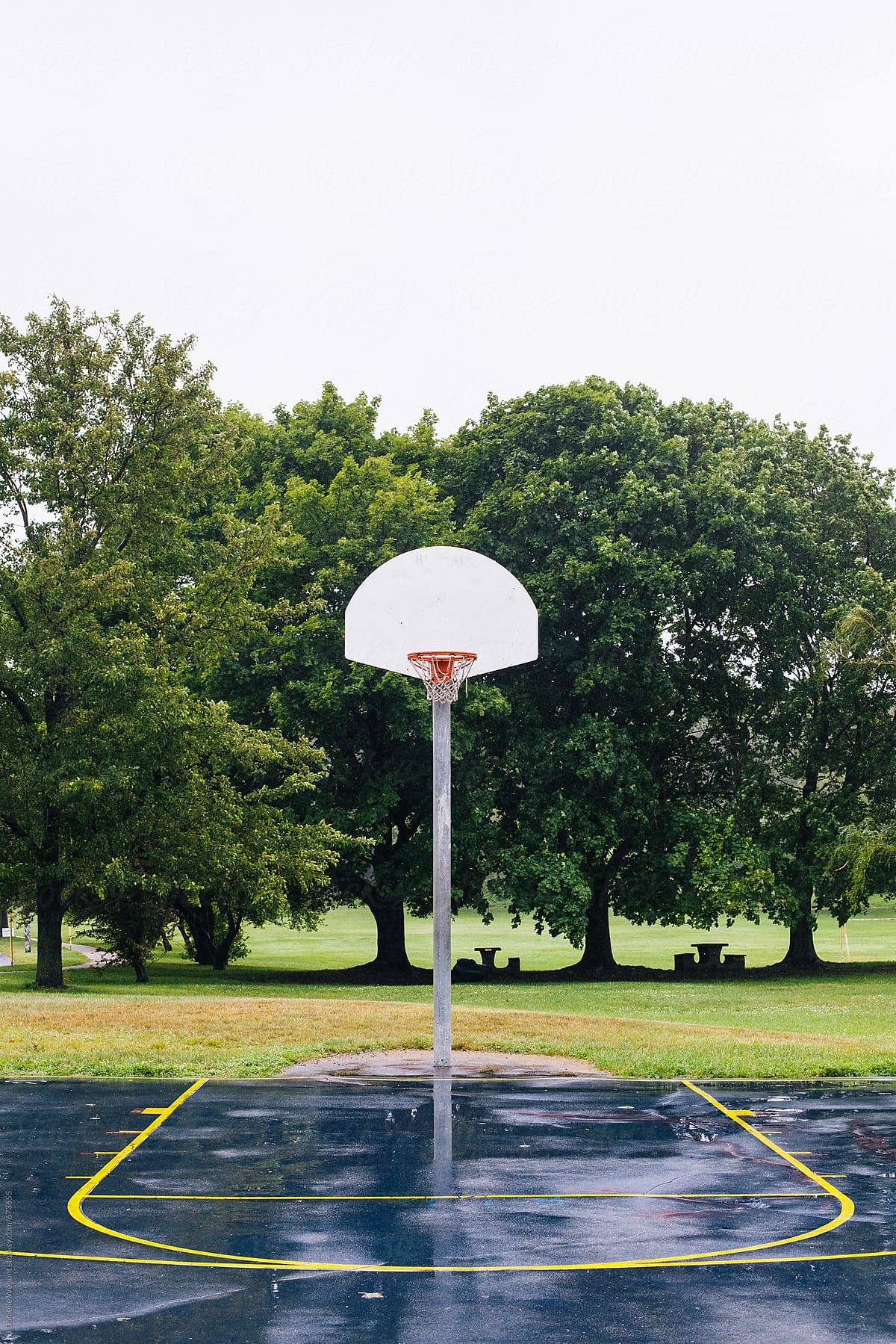 An empty basketball court after the rain.