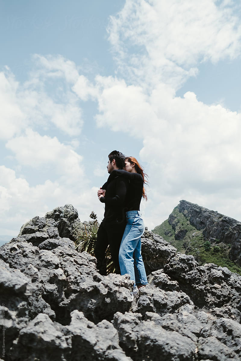 woman hugs her partner on a mountain