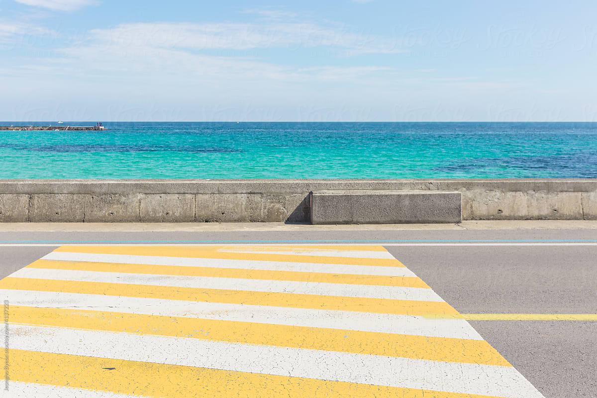 Sea and yellow striped road