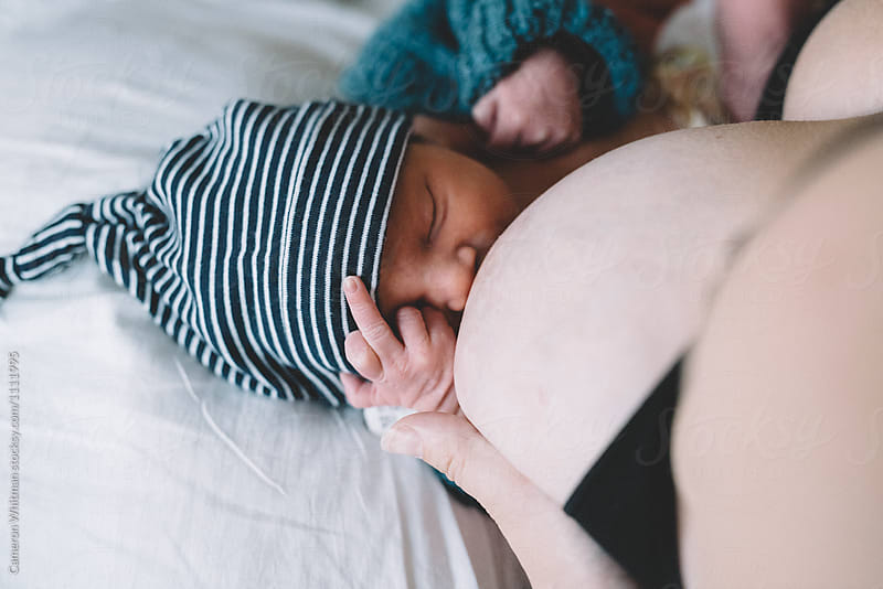 Newborn baby flipping off dad while breastfeeding