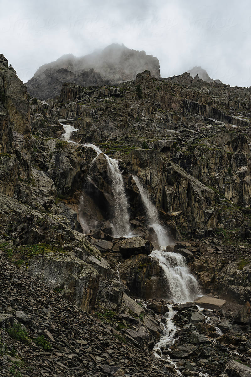 a small waterfall falling down a rocky mountainside