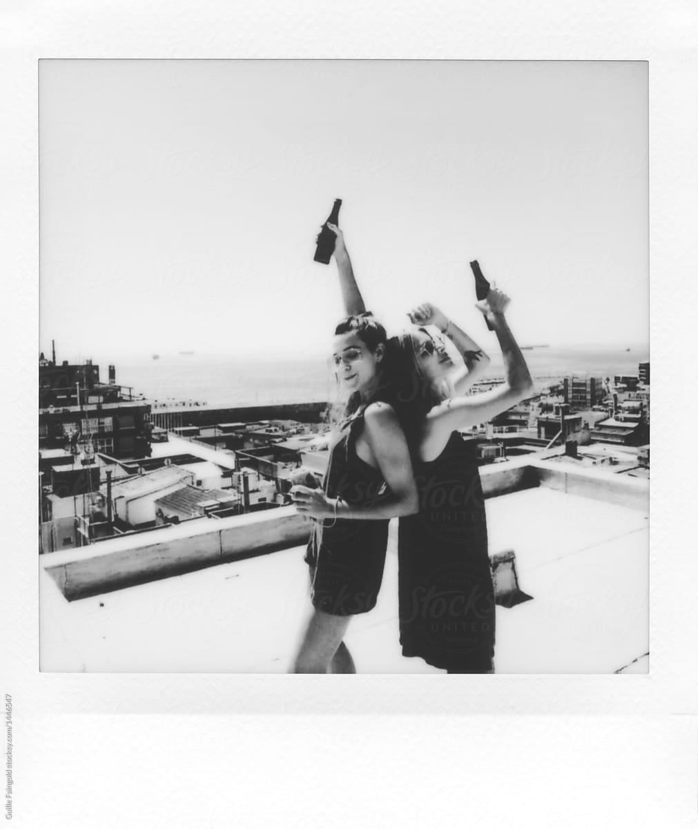 Girlfriends with beer on rooftop