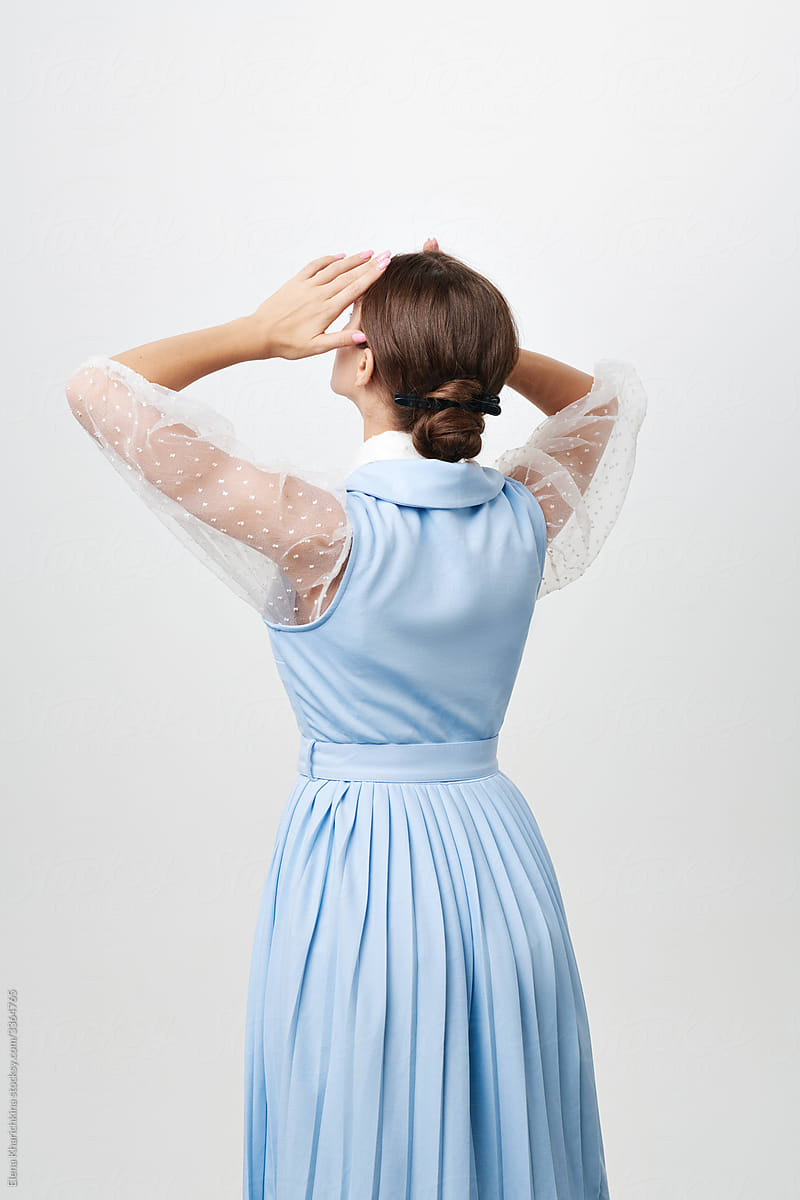 Silhouettes of a beautiful woman in a blue dress, back view.
