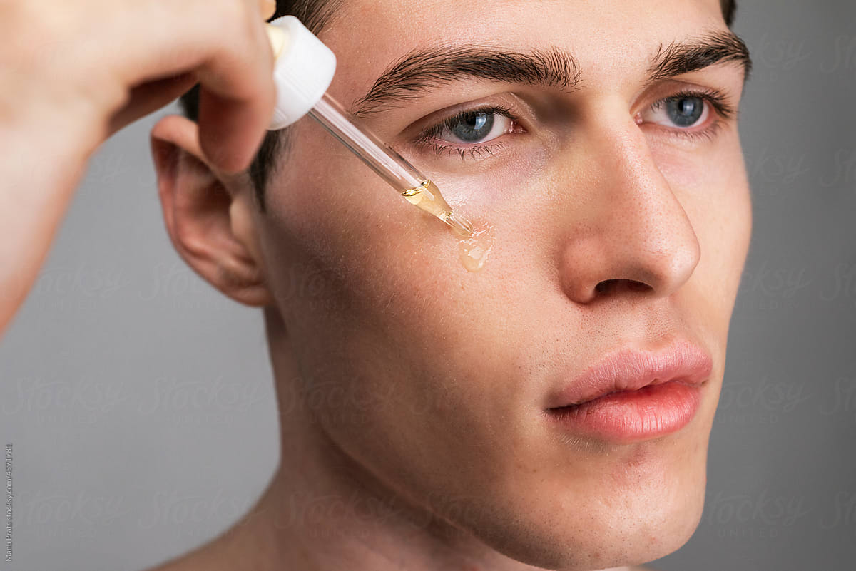 Serum dripping on male face, male skin care