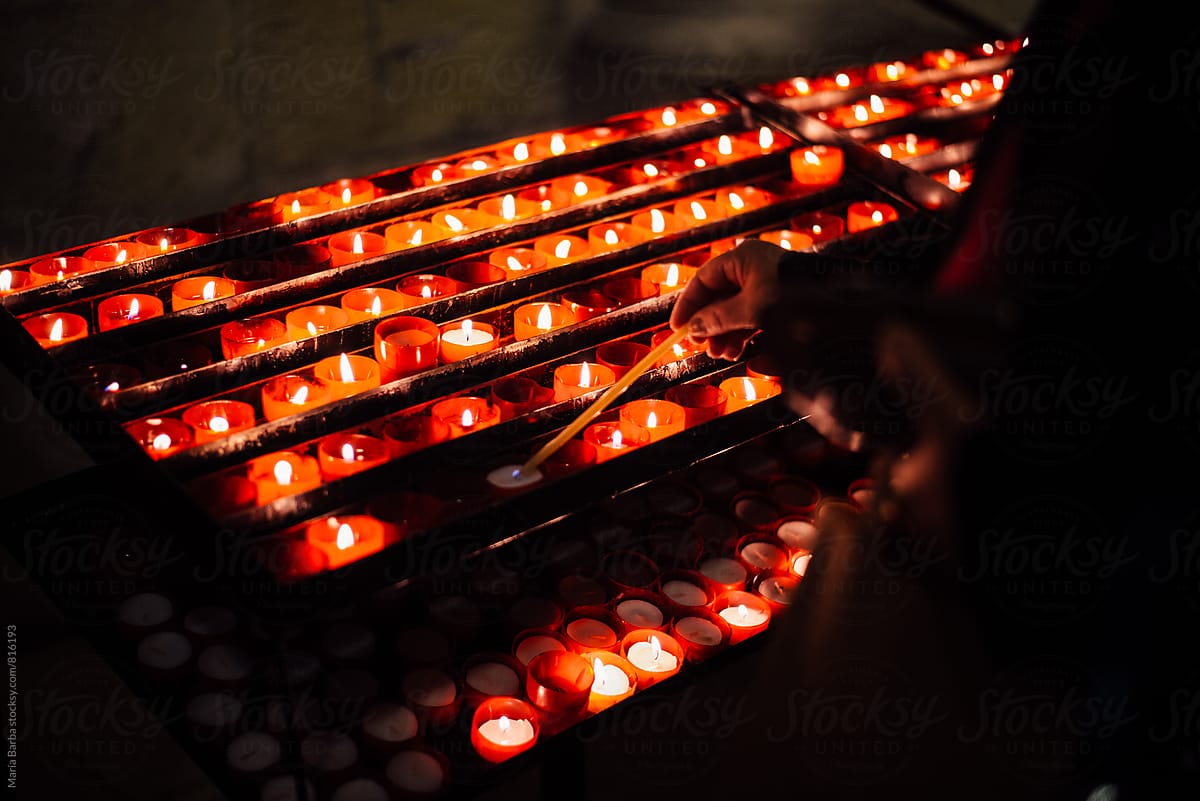 Lighting candles inside of a church.