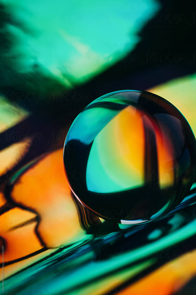 Crystal ball laying on holographic colorful background