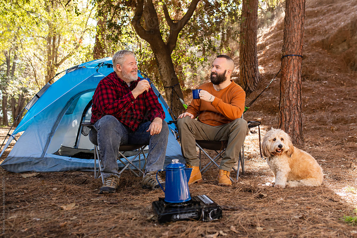 A Couple Of Men Enjoy Coffee At Their Campsite