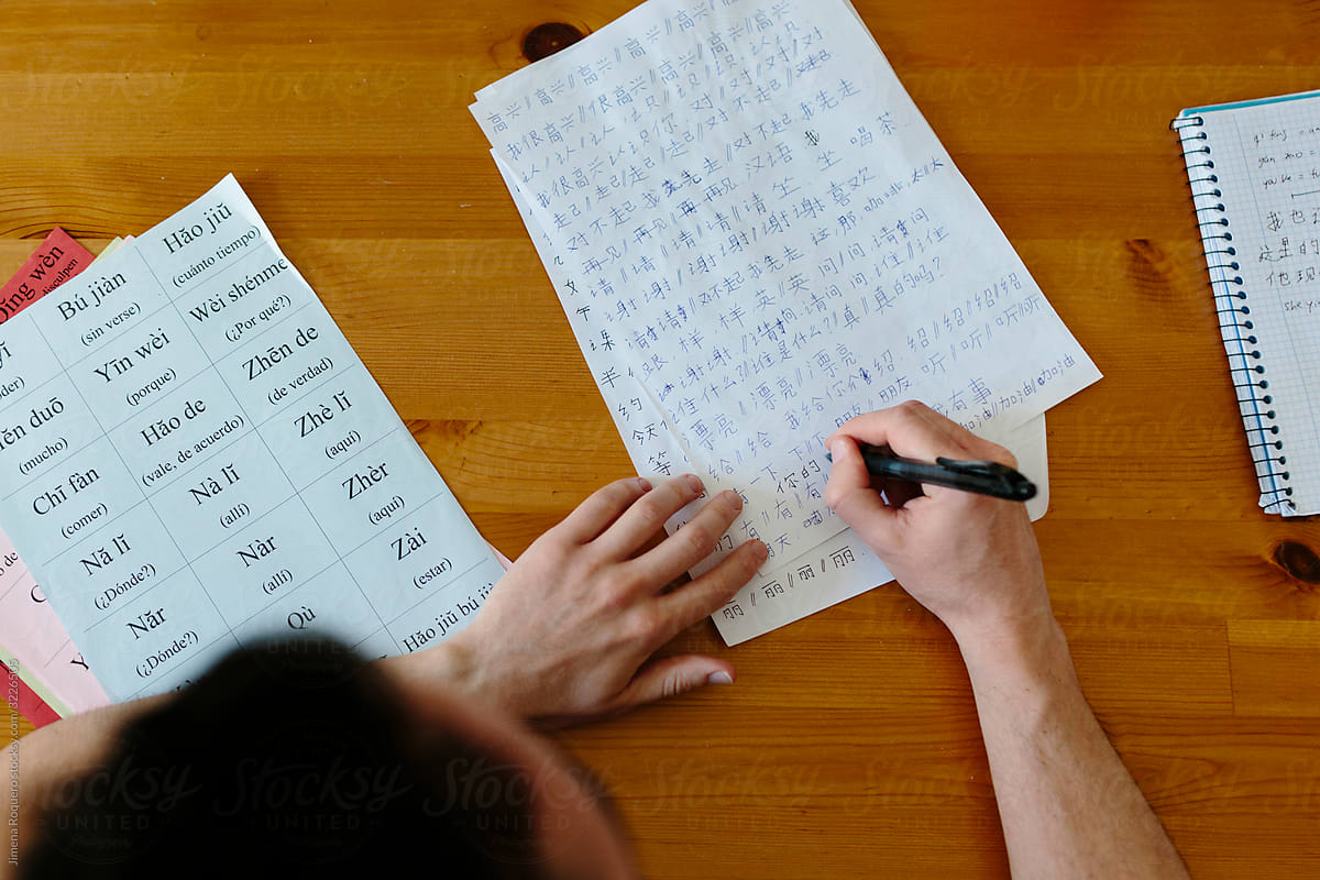 Hands of man writing Chinese characters