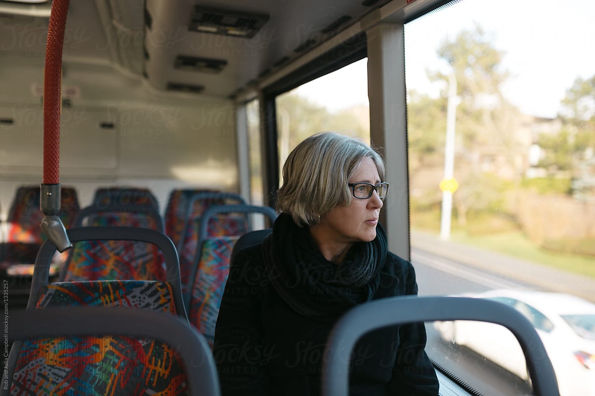 Thoughtful mature woman looking out bus window