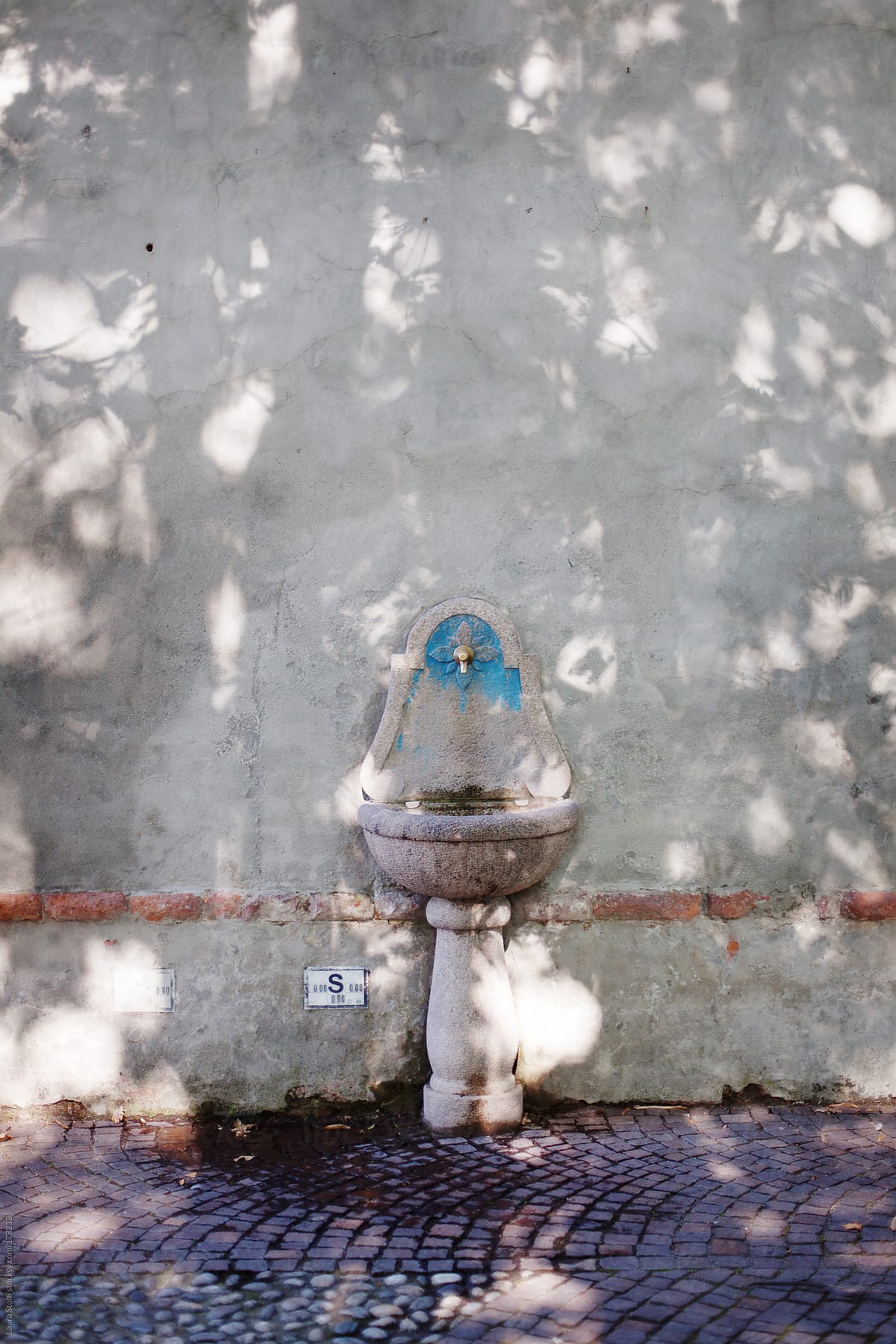 Stone  ancient drinking fountain in italian narrow street