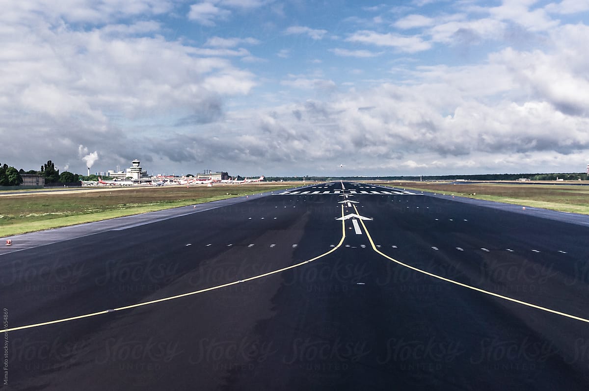 Runway with plane in distance taking off