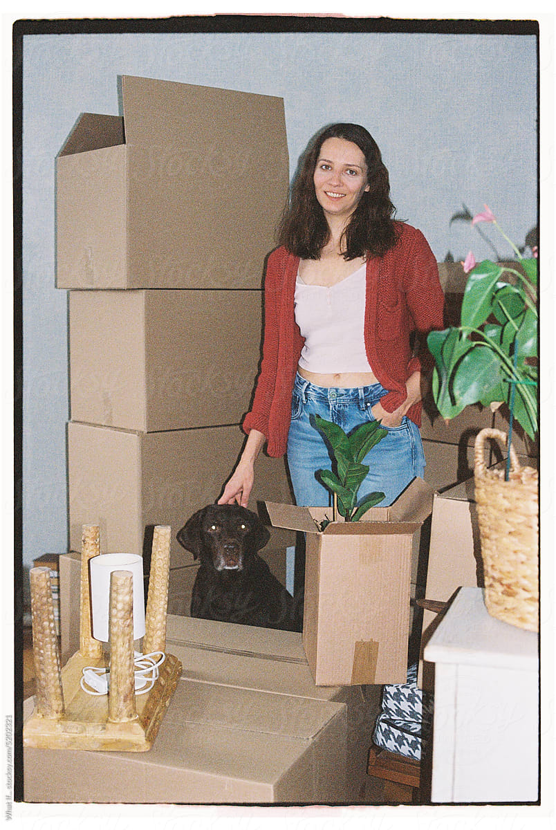Portrait of a dog and woman amongst the moving boxes.