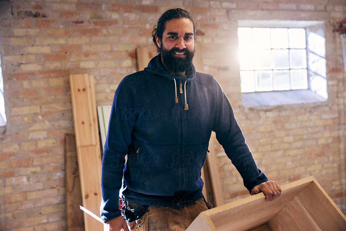 Smiling woodworker standing in his workshop