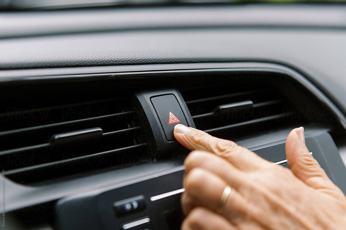 close up of finger pushing button in car