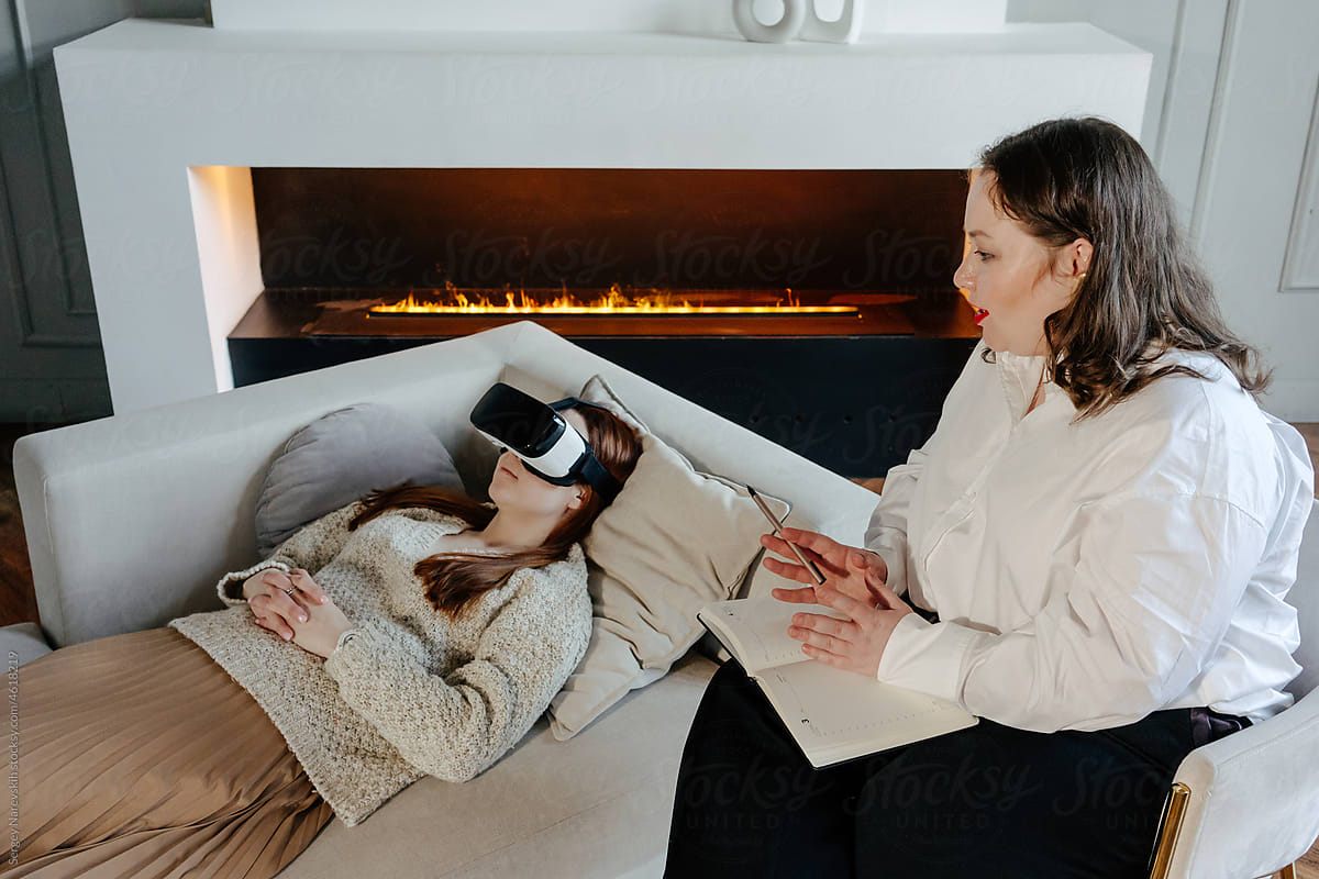 Patient in VR goggles listening to psychologist during therapy