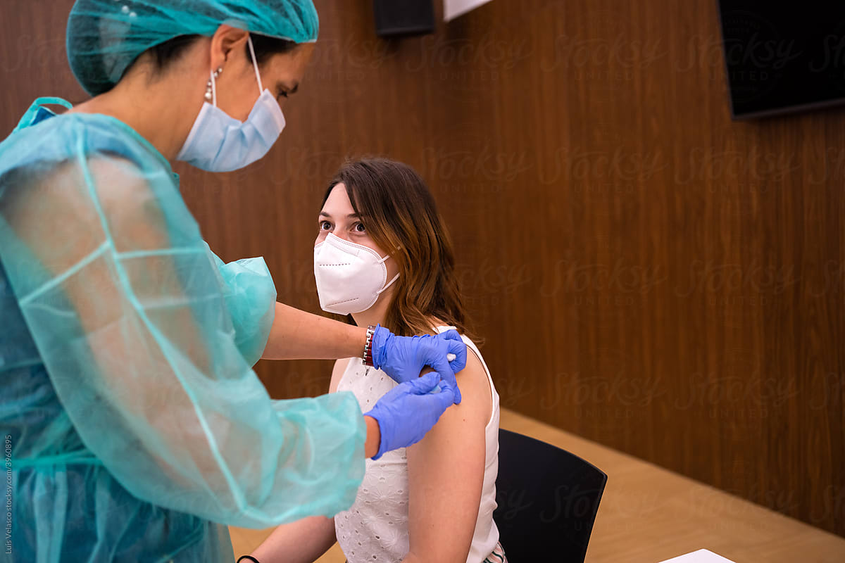 Nurse Giving Coronavirus Vaccination To A Woman Patient