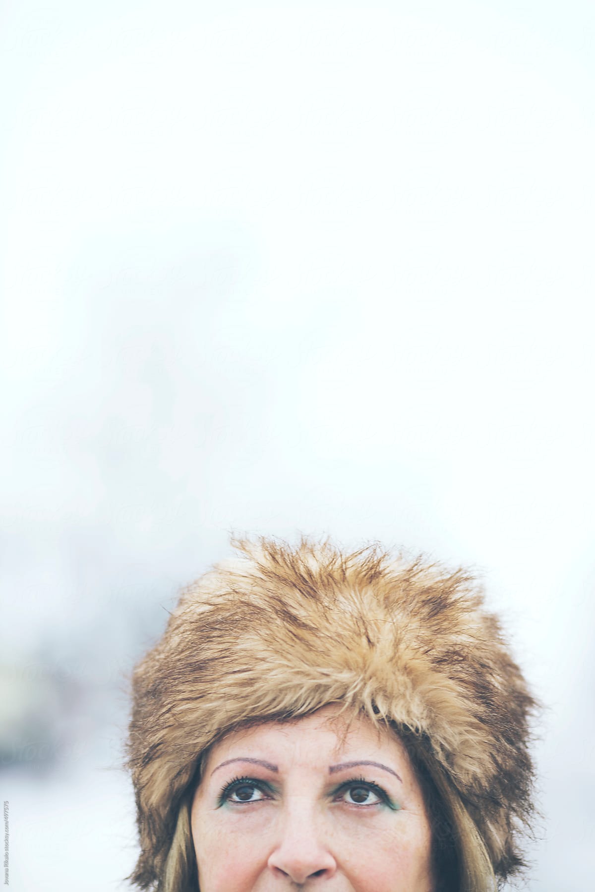 Woman wearing fur hat covered with snow