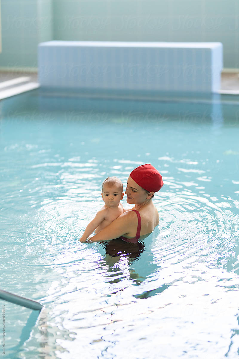Mother teaching baby swimming pool
