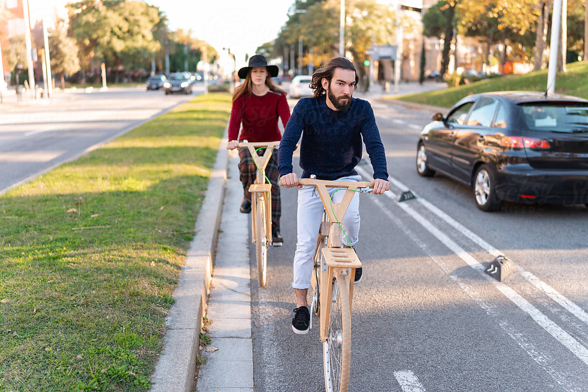 Friends riding wooden bicycles on bike path