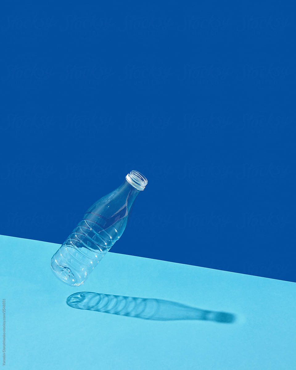 Open plastic bottle on a double blue background