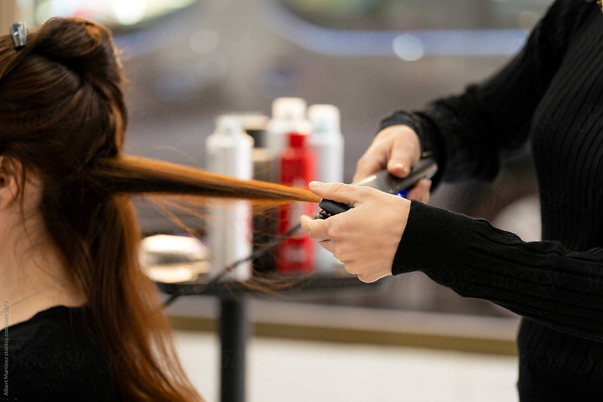 Hairdresser strengthening hair of customer in salon