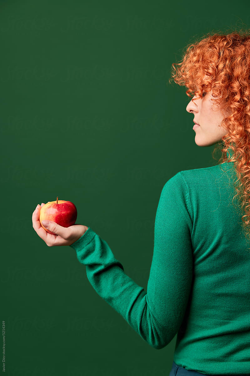 Curly redhead lady with apple