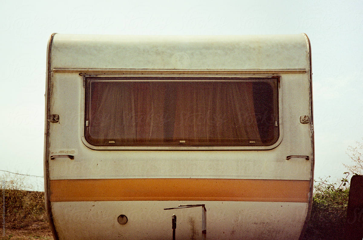 Vintage analog photograph of camping trailer window during summer trip