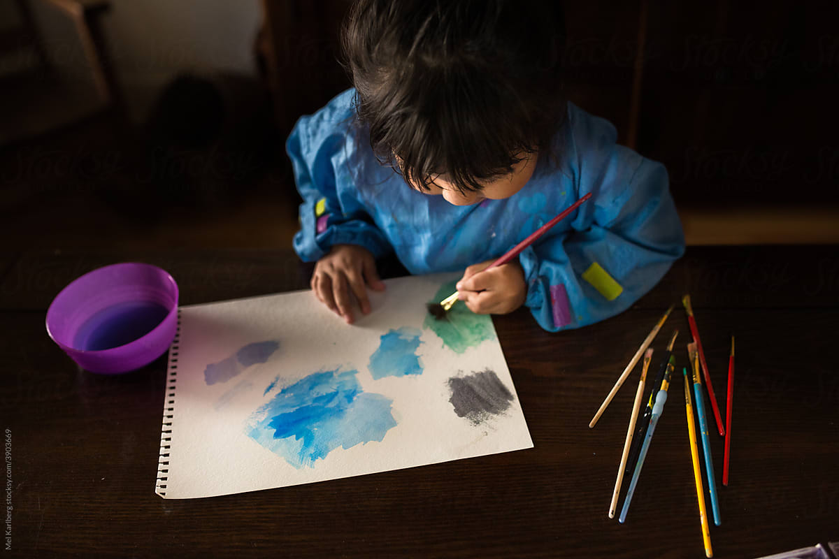 Young girl painting a colorful watercolor picture