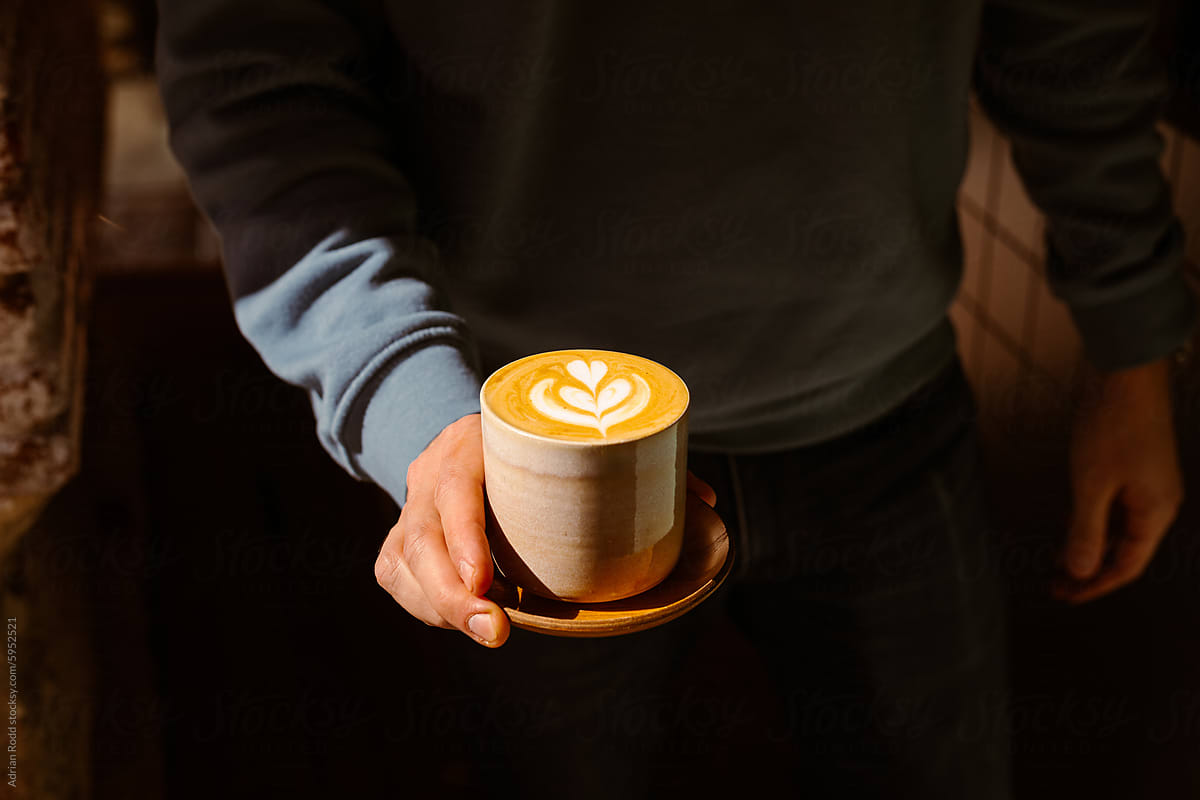 Barista holding a coffee in a specialty coffee shop
