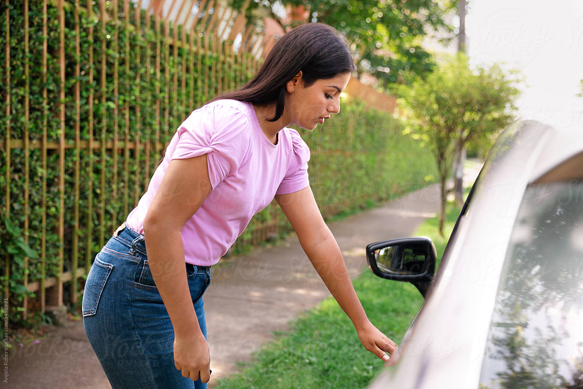 Young woman opening a car door